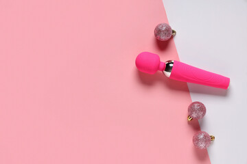 Vibrator and Christmas balls on color background