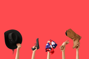 Female hands with cowboy accessories, gun and flag of USA on red background