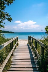 Obraz premium Wooden bridge leading to a beautiful sandy beach on a sunny day