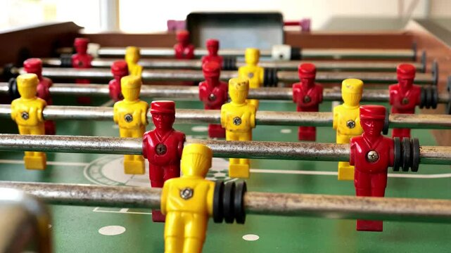 Table football. Table sports game.Yellow and red football players figures move on a green table . Slow motion. 4k footage