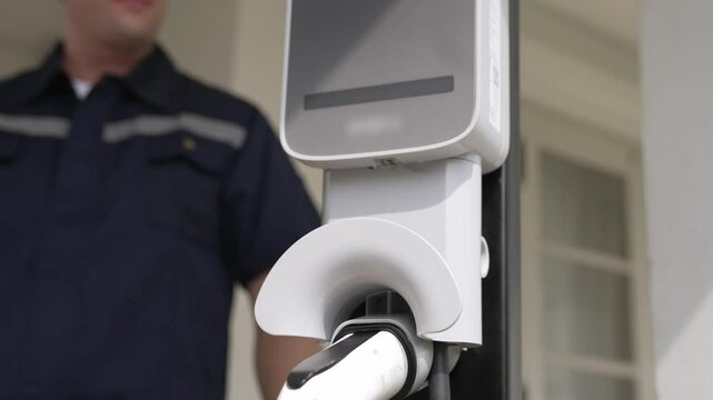 Qualified technician install home EV charging station, providing maintenance service for electric vehicle's battery charging platform at home. EV car technology for residential utilization. Fastidious