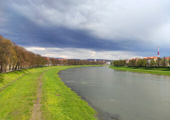 Scenic spring view of Uzhhorod city and Uzh river, Transcarpathia, Ukraine. Scenic view of a calm river with lush banks in early spring