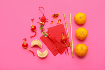Fortune cookies with mandarins and Chinese symbols on pink background. New Year celebration