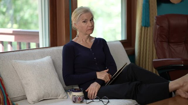 Portrait of smiling mature blonde woman 50s years old look aside close her mouth lock and throw away key as hearing a secret.