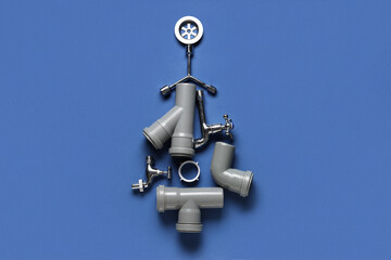 Christmas tree made of plumber's items on blue background