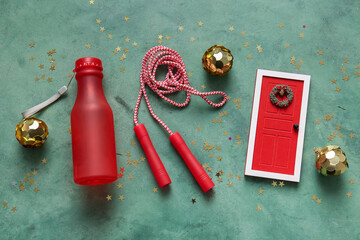 Composition with skipping rope, bottle of water and Christmas decorations on color background