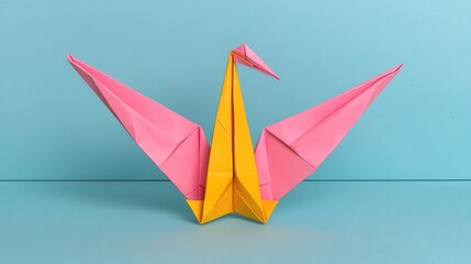 Pink and Yellow Origami Crane Paper Sculpture on Blue Background