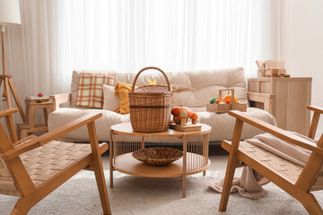 Interior of living room with autumn decor, sofa and armchairs