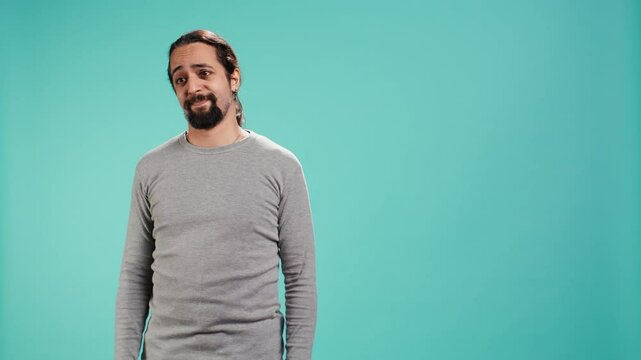 Man shrugging shoulders, expressing uncertainty or helplessness, having troubled facial expression. Person unable to provide assistance to friend, feeling powerless, studio background, camera B