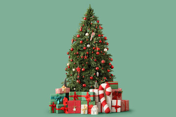 Beautiful decorated Christmas tree with gift boxes and decorations on green background