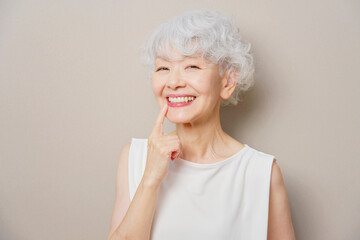 歯を指差すシニア女性