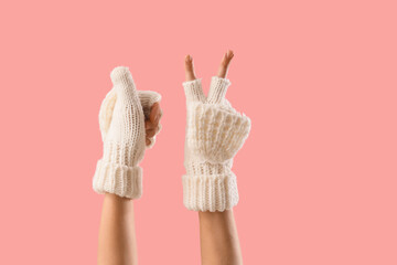 Woman in warm gloves gesturing on pink background