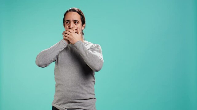 Man covering eyes, ears and mouth, imitating three wise monkeys. Arab person doing dont see, dont hear and dont speak hand gesturing concept, studio background, camera B