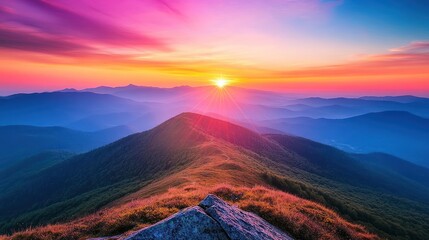 Fototapeta premium A vibrant sunrise over a mountainous landscape, with layers of blue mountains bathed in the golden light.
