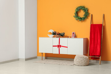 Interior of modern room with commode, ladder and Christmas decorations