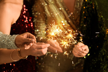 Beautiful women with Christmas sparklers at Christmas party, closeup