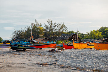 Beautiful fine white sand beach with fishing boats at the shore.