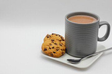 cookies with chocolate chips and a cup with a hot drink on white background