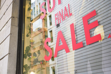 Large red Sale text letters on a glass wall obstruct a view inside the popular fashion store
