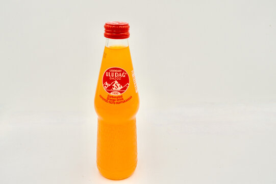 A closeup of a bottle of Uludag Turkish orange soda against a white background.