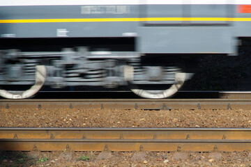The undercarriage of a train car moving along rails at high speed. Blurred motion.