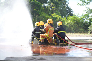 Firefighters using Twirl water fog type fire extinguisher to fighting with the fire flame from oil to control fire not to spreading out. Firefighter and