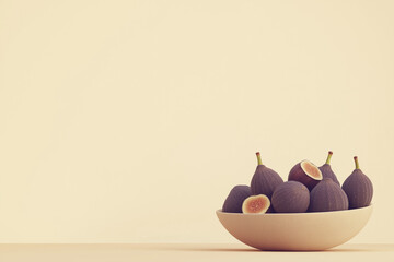 Fresh figs in white bowl on neutral background setting