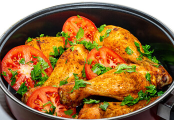 Golden baked chicken legs with tomatoes and parsley