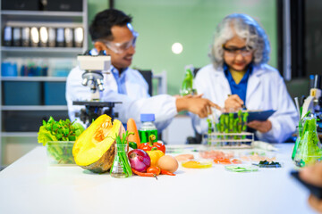 A reliable middle-aged Asian male researcher collaborates with experienced gray-haired elderly Asian female nutritionist in laboratory, food ingredients, extracts, their impact on nutrition health.