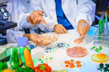 A reliable middle-aged Asian male researcher collaborates with experienced gray-haired elderly Asian female nutritionist in laboratory, food ingredients, extracts, their impact on nutrition health.