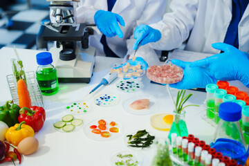 A reliable middle-aged Asian male researcher collaborates with experienced gray-haired elderly Asian female nutritionist in laboratory, food ingredients, extracts, their impact on nutrition health.