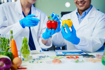 Reliable middle-aged Asian male researcher collaborates with experienced gray-haired elderly Asian female nutritionist in laboratory, focusing on food ingredients, extracts, nutrition and health.