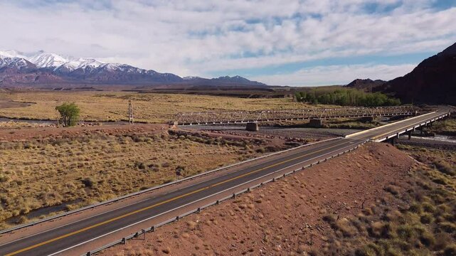 Steppe landscape near Uspallata, Argentina, with the snowcapped Andes mountains in the distance.