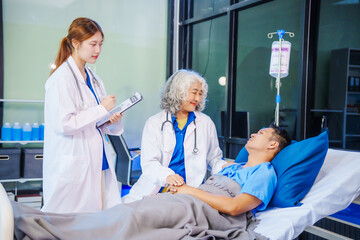 A middle-aged man lies bedridden on hospital bed, closely monitored by an old Asian woman doctor...