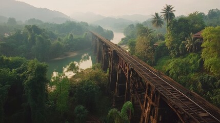 Obraz premium The iconic Bridge over the River Kwai, an essential historical landmark surrounded by lush greenery.