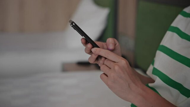 Close-up. An unrecognizable woman uses a smartphone. Hands and phone in the frame, internet technology and wi-fi.