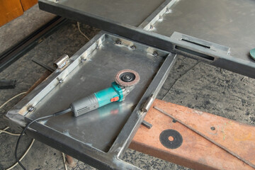 Angle grinder machine on iron gate. Metalworking