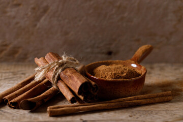 Aromatic cinnamon sticks and powder on wooden table.