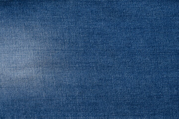 A close-up view of textured blue denim fabric showcasing its weave and color variations