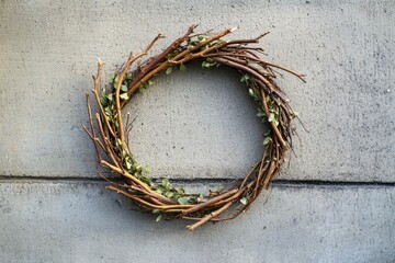 Fototapeta premium A Rustic Twig and Leaf Wreath on a Grey Concrete Wall