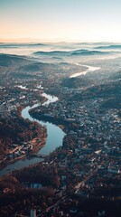 Fototapeta premium A stunning aerial view of a winding river surrounded by hills, showcasing a serene landscape with soft morning light.