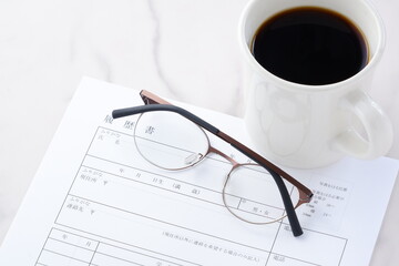コーヒーを飲みながら、履歴書を書く
