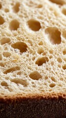 Close-up view of a fresh slice of bread showcasing its airy texture and golden crust, highlighting its delicious, fluffy interior.
