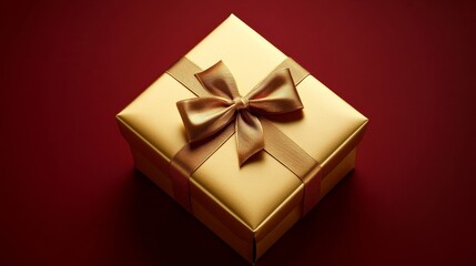 A luxurious gold gift box with an elegant satin ribbon on a deep red background