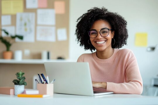 Joyful woman with laptop in modern creative workspace