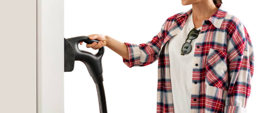 Isolated female person in red plaid shirt with electric plug in her hand on electric vehicle  charging station.
