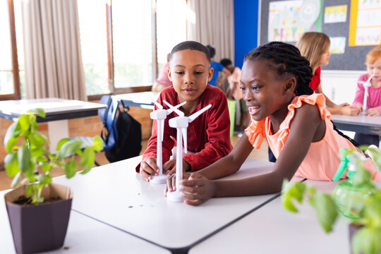 Building wind turbine models in school classroom, diverse children engaging in STEM activities - Powered by Adobe