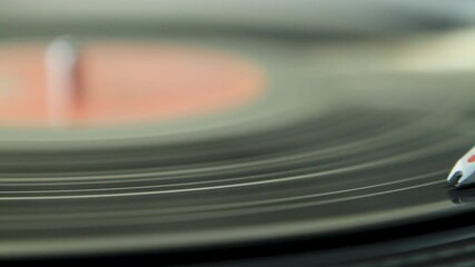 A close-up of a turntable needle playing a vinyl record, capturing the grooves in detail