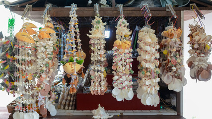 Langkawi, Malaysia: October 3rd, 2024: The wind chimes are made with various types of seashells, including conch shells, cowrie shells, and scallop shells.