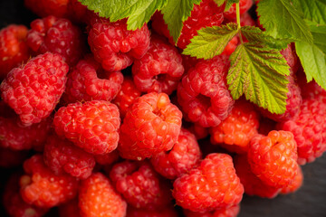 Ripe and juicy raspberry on the dark rustic background. Selective focus. Shallow depth of field. Shot from above.